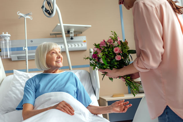 病室で花を渡す女性